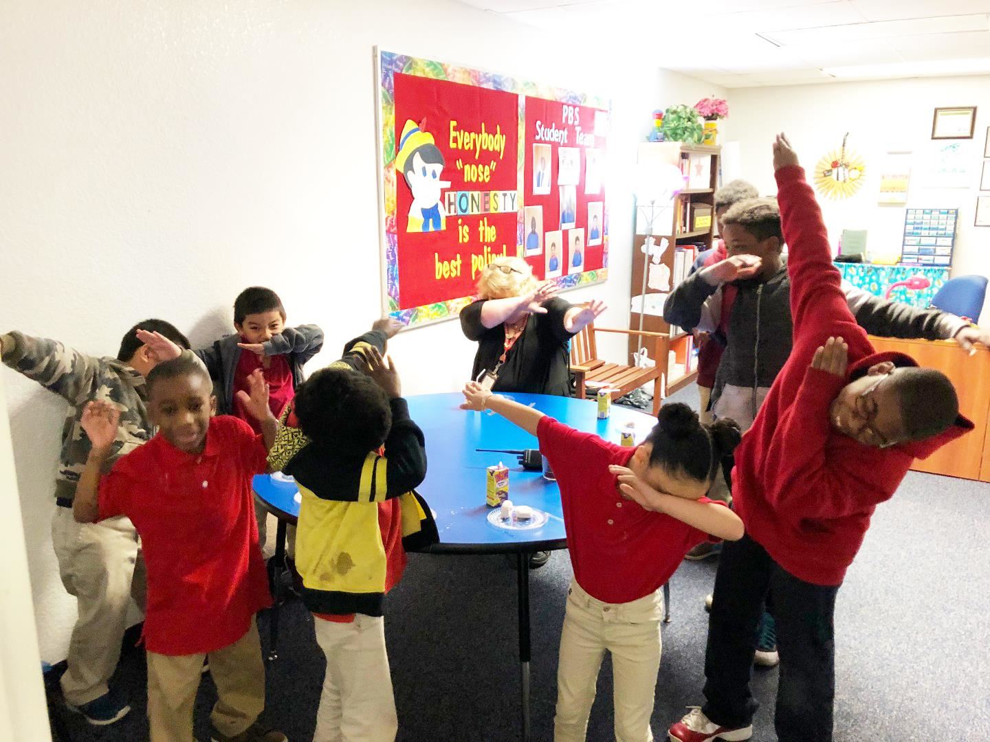 Students having donuts with the Principal as a reward for positive behavior